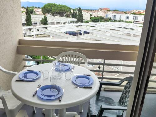 une table blanche avec des assiettes et des verres sur un balcon dans l'établissement Apartment Copacabana-24 by Interhome, à Canet
