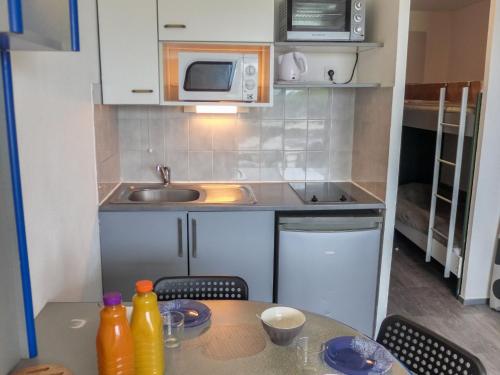 une cuisine avec une table avec des chaises et un micro-ondes dans l'établissement Apartment Copacabana-24 by Interhome, à Canet