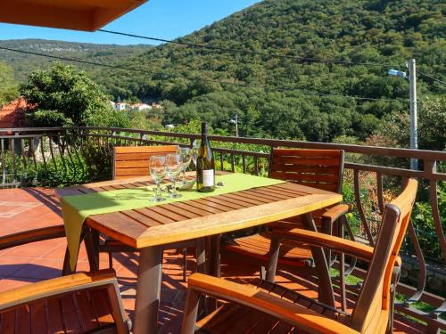 einen Holztisch mit Weingläsern auf dem Balkon in der Unterkunft Apartment Regina - ICS103 by Interhome in Porozina