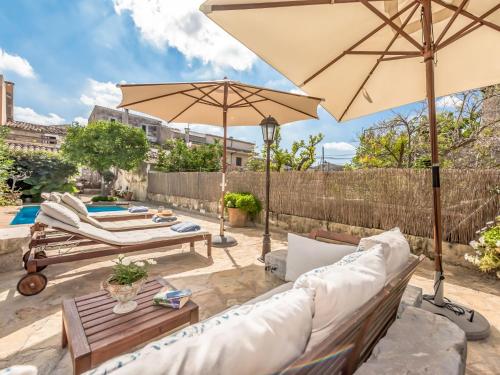 a patio with two couches and an umbrella at Holiday Home Sa Teulera by Interhome in Campanet