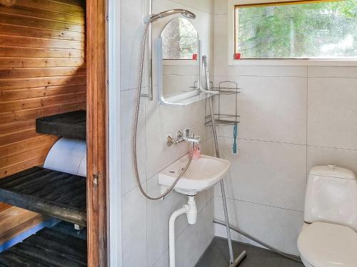 uma casa de banho com um lavatório e um WC em Holiday Home Parkkisenniemen lomamökit by Interhome em Karvonen