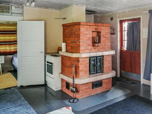 uma cozinha com uma lareira de tijolos num quarto em Holiday Home Parkkisenniemen lomamökit by Interhome em Karvonen
