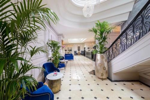 a lobby with blue chairs and potted plants at Killarney Dromhall Hotel in Killarney