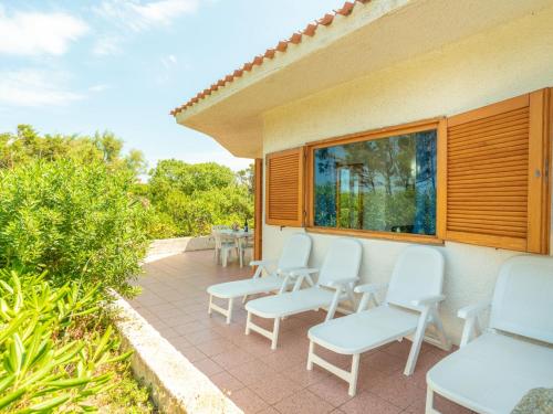 a patio with white chairs and a window at Holiday Home Trebbiano by Interhome in Greuli 