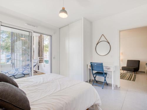 a bedroom with a bed and a desk and a chair at Apartment les Terrasses de Capbreton-2 by Interhome in Capbreton