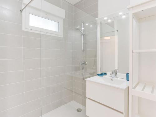 une salle de bain blanche avec une douche et un lavabo dans l'établissement Apartment les Terrasses de Capbreton-1 by Interhome, à Capbreton