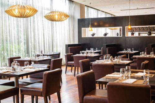 a dining room with tables and chairs and chandeliers at Radisson Blu Hotel, Addis Ababa in Addis Ababa