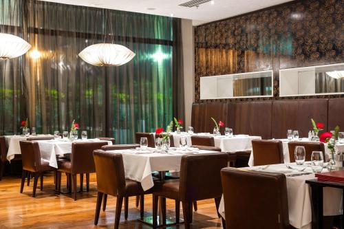 a dining room with white tables and chairs and chandeliers at Radisson Blu Hotel, Addis Ababa in Addis Ababa