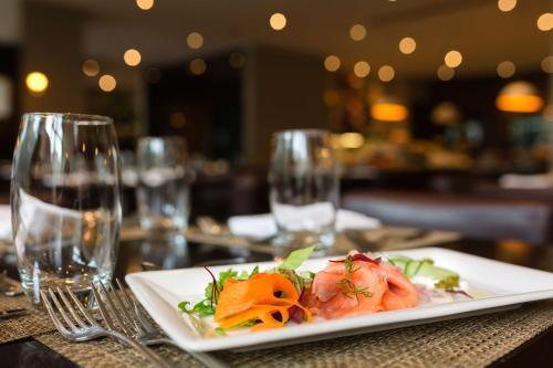 a plate of food on a table with wine glasses at Radisson Blu Hotel, Addis Ababa in Addis Ababa
