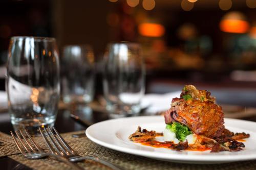 a plate of food with broccoli on a table with glasses at Radisson Blu Hotel, Addis Ababa in Addis Ababa