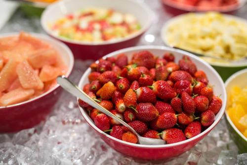 a bowl of strawberries on a table with other bowls of food at Radisson Blu Hotel, Addis Ababa in Addis Ababa