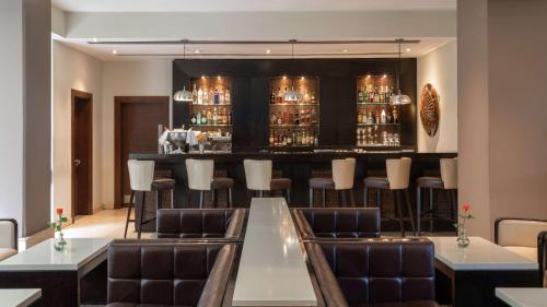 a restaurant with a bar with leather chairs and tables at Radisson Blu Hotel, Addis Ababa in Addis Ababa