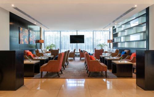 a restaurant with tables and chairs and a flat screen tv at Radisson Blu Hotel, Addis Ababa in Addis Ababa
