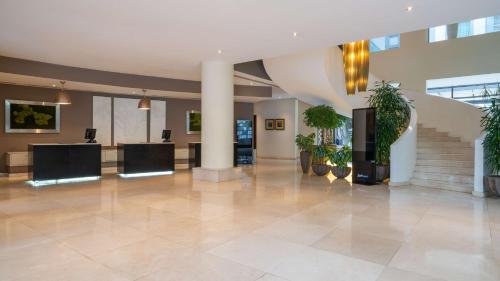 a lobby with potted plants and stairs in a building at Radisson Blu Hotel, Addis Ababa in Addis Ababa