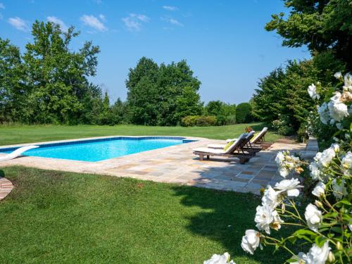 een vrouw op een bankje naast een zwembad bij Holiday Home Villa Remotti by Interhome in Fubine