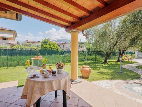 a table and chairs on a patio under a pergola at Holiday Home Colli by Interhome in Massa