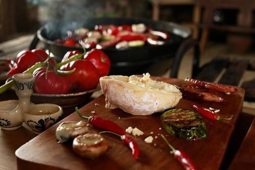 a wooden cutting board with vegetables on a table at La Hansi in Crit in Criţ