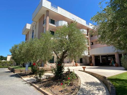 a building with trees and flowers in front of it at Apartment Comfort-3 by Interhome in San Vincenzo