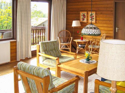 ein Wohnzimmer mit Stühlen, einem Tisch und einer Veranda in der Unterkunft Apartment Am Hohen Bogen-23 by Interhome in Arrach