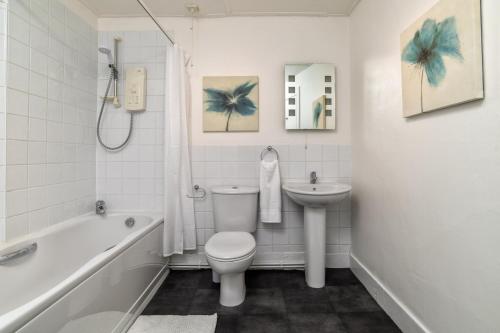 a white bathroom with a toilet and a sink at The Green Inn Rooms in Ballater
