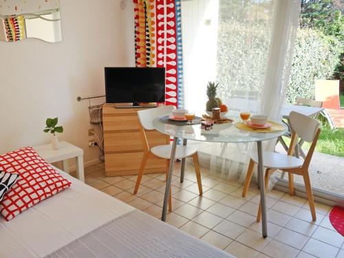 カルナックにあるApartment Plein Soleil by Interhomeのテーブルと椅子、テレビが備わる客室です。