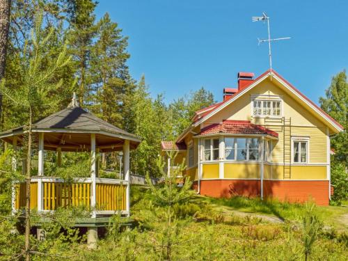 une maison jaune et orange avec un kiosque dans l'établissement Holiday Home Villa kukkapää by Interhome, à Sulkava