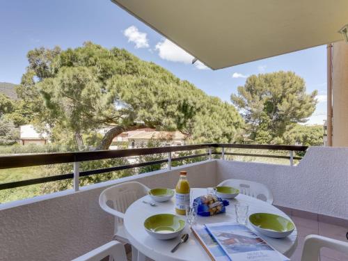 een witte tafel en stoelen op een balkon met uitzicht bij Studio Sémaphore-2 by Interhome in Cavalaire-sur-Mer