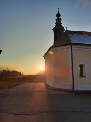 a small church with the sunset in the background at Glückchalet in Rettenschöss