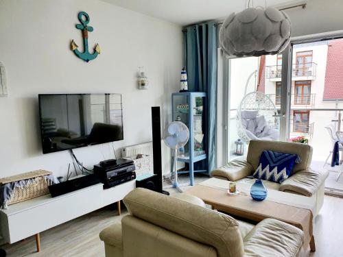 uma sala de estar com um sofá e uma televisão em Stella Baltic big terrace 3 Zimmer frei parking em Świnoujście