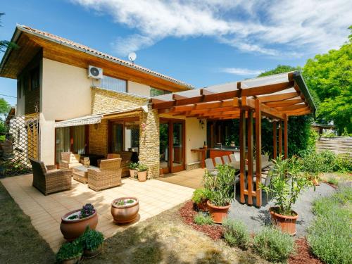 a house with a patio with potted plants on it at Holiday Home Villa Mediterran by Interhome in Balatonszemes