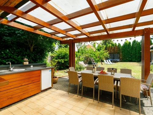 uma cozinha exterior e uma área de refeições com uma pérgola de madeira em Holiday Home Villa Mediterran by Interhome em Balatonszemes