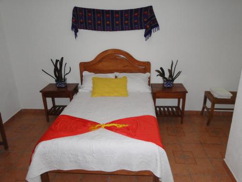 a bedroom with a bed with a yellow pillow and two tables at El Molino Hotel Boutique in Río Verde