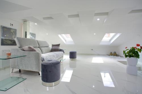 a white living room with a couch and a table at Casa Aurelia - Aurelia Design in Krk