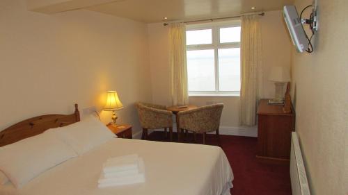 a hotel room with a bed and a window at The Wimslow in Morecambe