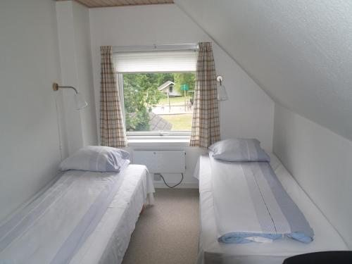 a small room with two beds and a window at Riis Feriepark in Give