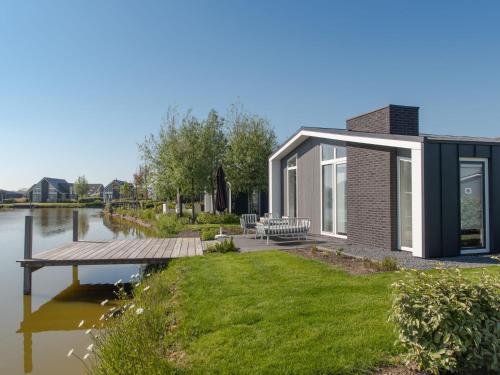 a house on the water with a dock at Holiday Home Ruisweg 28 by Interhome in Wemeldinge