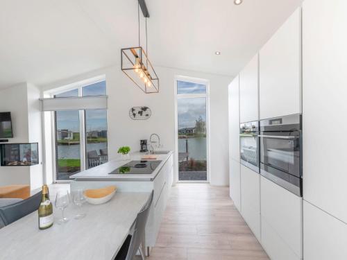 a kitchen with white cabinets and a large window at Holiday Home Ruisweg 28 by Interhome in Wemeldinge
