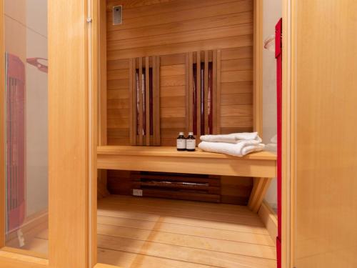 a walk in shower with wooden cabinets and towels at Holiday Home Ruisweg 28 by Interhome in Wemeldinge