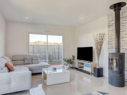 Il comprend un salon doté d'un canapé, d'une télévision et d'une cheminée. dans l'établissement Holiday Home La Bruyère by Interhome, à Saubion