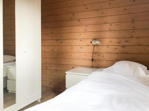 a bedroom with a wooden wall with a bed and a lamp at Holiday Home De Brenkberg-1 in Schinveld