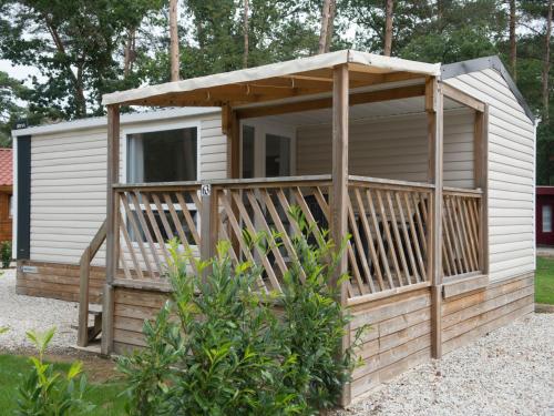 a cabin with a porch and a deck at Holiday Home De Brenkberg-1 in Schinveld