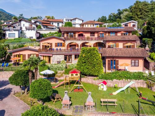 a large house with a playground in front of it at Apartment Residenza Agrifoglio-6 by Interhome in Luino