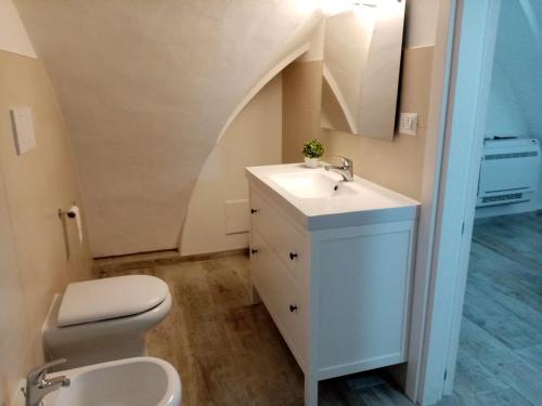 a bathroom with a sink and a toilet with an attic at I Nidi di Colombo in Castrignano del Capo