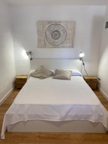 a bedroom with a large white bed with two night stands at Villa Maioli in Olivella