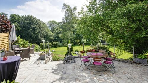 un patio con mesa y sillas en un jardín en Landhaus am Rehwald en Donzdorf