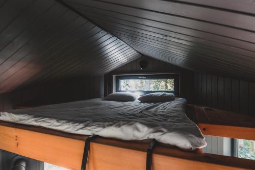 Cama en habitación negra con ventana en Hekso treehouse, 