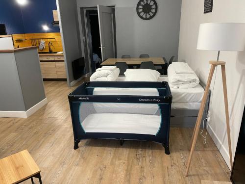 une chambre avec trois lits et une table avec une horloge dans l'établissement Logement cosy avec terrasse proche zoo de beauval, à Noyers-sur-Cher