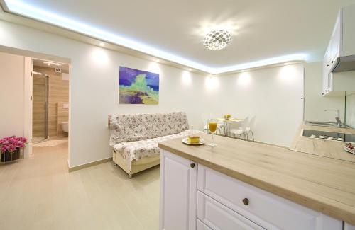 een keuken en een woonkamer met een bank en een tafel bij Casa Aurelia - Mali Tone in Krk