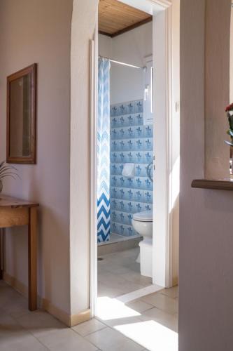 a bathroom with a toilet and a blue tiled wall at Aroma Studios in Lakíthra