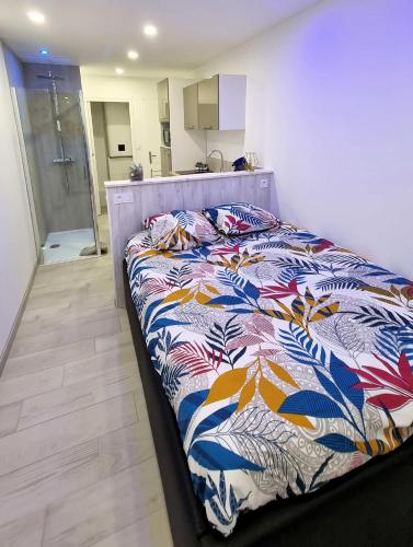 une chambre avec un lit avec une couette colorée dans l'établissement Studio Port Nature 2 Castalie, au Cap d'Agde